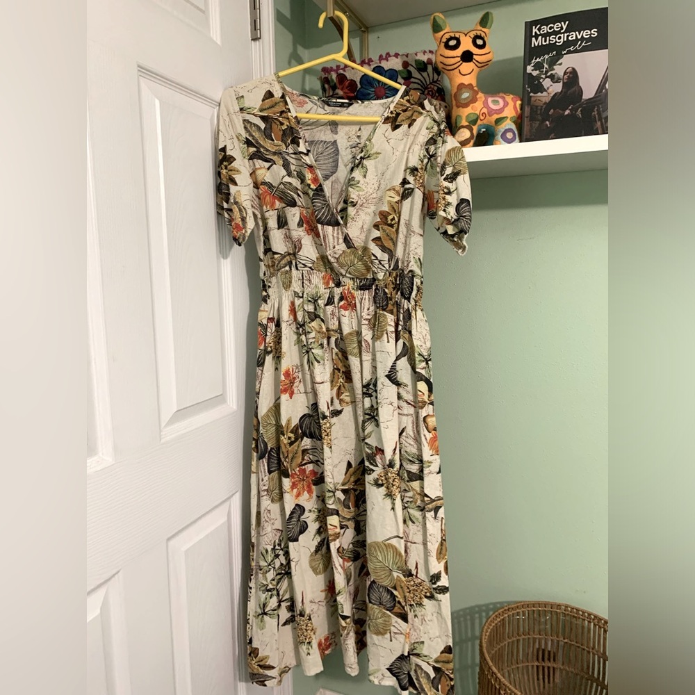 Beautiful Beige dress with exotic leaf decoration.